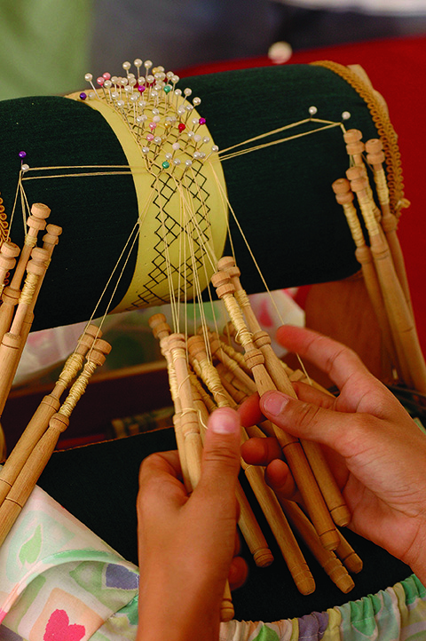 Mundillo is a decorative lace made by braiding and twisting lengths of thread bound on bobbins.