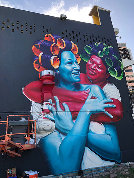 Dominican artist Evaristo Angurria painted a mural that embodies two women – a red and blue – to represent a fraternal tie between Puerto Rico and its sister country, the Dominican Republic.